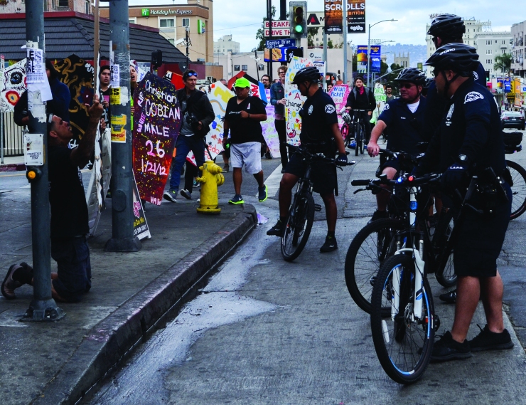 LAPD officers gather in front of prosters on the intersection of 6th Street and South Bonnie Brae Street on April 7 2015. The demonstration was peacefull throughout the march to downtown Los Angeles.